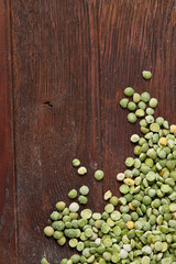 Green peas on rustic wooden background, close-up, top view, selective focus.