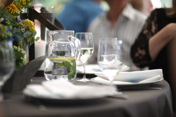 Pitcher with cold water with lemon and mint on the table in the restaurant