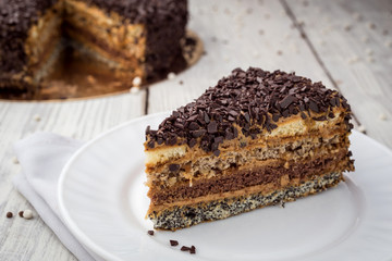 Dark chocolate vegan cake with candies and nuts on wooden background