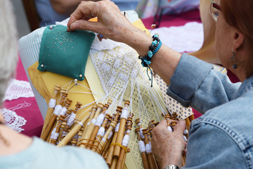 Active senior people workshop with traditional bobbin lace crochet. Hands detail and empty copy...