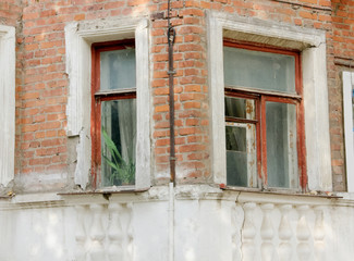 Fototapeta na wymiar Windows on the wall of an old brick house with architectural decor