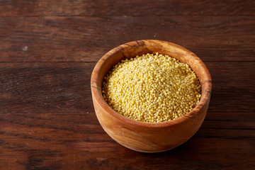 Lentils in a wooden bowl on rustic wooden background, top view, close-up, selective focus.