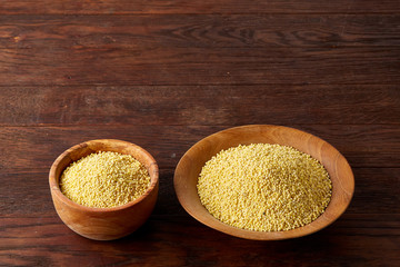 Lentils in a wooden bowl on rustic wooden background, top view, close-up, selective focus.