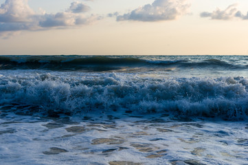 sea landscape is a pebbly beach with waves in white foam