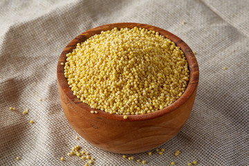 Lentils in a wooden bowl on rustic wooden background, top view, close-up, selective focus.