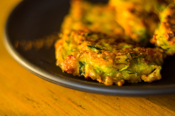 Fried vegetable fritters with zucchini, carrots, herbs, eggs, and cheese.