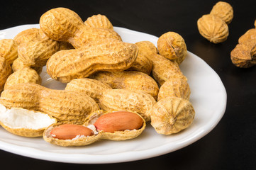 Peanuts in shell on dark background, close up