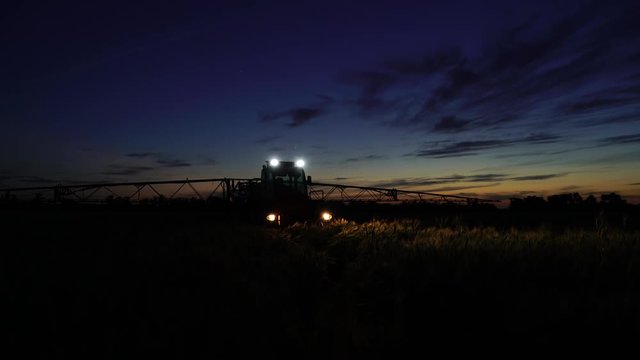 Machine for spraying pesticides and herbicides in the field at night. 4K video