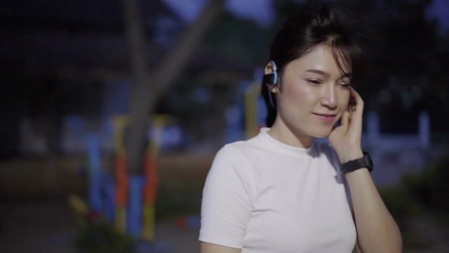 slow-motion of sporty woman listening to music with wireless headphones