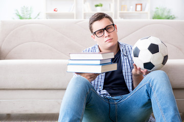 Young student trying to balance studying and playing football