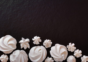 Simple white meringue decoration on black food backgrounds
