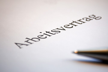 Obraz premium Arbeitsvertrag mit Stift in deutsch auf weissen Papier
