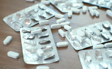 Blisters of pills and white pills on the table. Closeup.