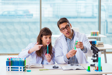 Two chemists working in lab experimenting