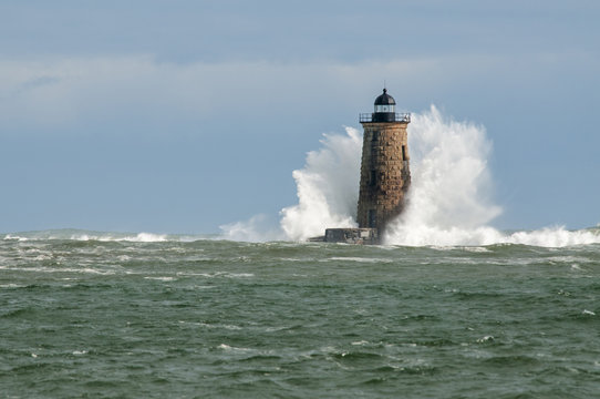 Large Wave Covers Stone Lighthouse Tower in Maine