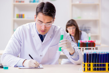 Two chemists working in lab experimenting