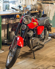 Red vintage motorcycle parked in the garage