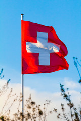 Swiss Confederation, Switzerland national flag waving on blue sky background