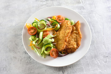 Vegetable salad and breaded chicken breast