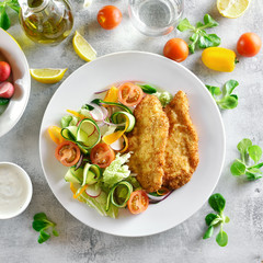 Vegetable salad and breaded chicken breast