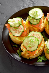 Sandwiches with salmon, scrambled eggs and cucumber