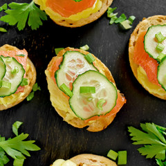 Sandwiches with salmon, scrambled eggs and cucumber