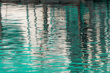 Reflection of  a pier in the waters of lake created by the light of the setting sun forming...