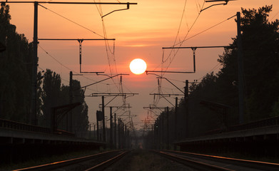 Fototapeta na wymiar Railway at sunset, a platform of the railway with ozhidayuschimi passengers