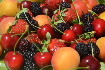 Berries overhead closeup colorful assorted mix of strawberry, blueberry, raspberry, blackberry, red currant in studio on dark background