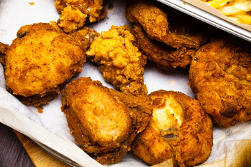 Fried chicken wings served on the paper napkins. Delicious meat meal served on the plate. Fast food chicken wings fried in the eggs. Unhealthy food concept.