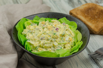 Bowl of egg salad with lettuce and toast