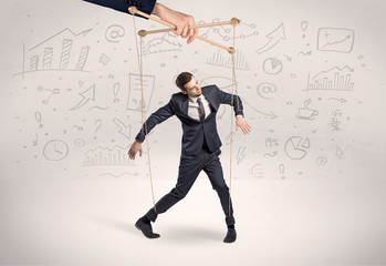 Puppet employee controlled by a big hand with documents and staffs around
