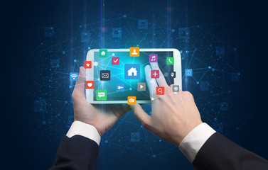 Hand using tablet with colorful bounce application symbols and icons concept
