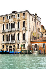 Fototapeta na wymiar Gothic building on The Grand Canal with a row of blue Gondolas, Venice, Italy.