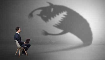 Young businessman staying and  negotiate with a monster shadow
