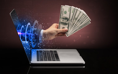 Hand with money coming out of a laptop with sparkling effects
