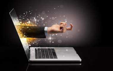 Hand with money coming out of a laptop with sparkling effects
