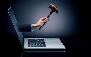 Hand with hammer coming out of a laptop with sparkling effects
