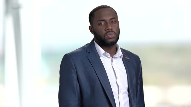 Black businessman adjusting his shirt. Confident dark-skinned entrepreneur going for a work. Stylish afro-american businessman.