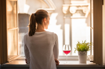 Young woman relaxing at home looking the window.
