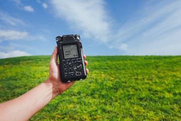portable audio recorder in hand field recording ambient sounds of nature