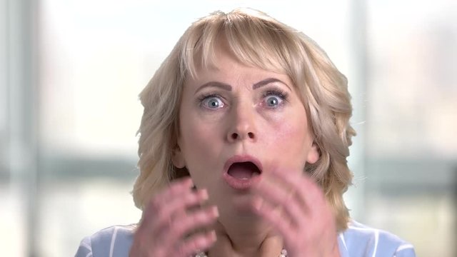 Face of shocked terrified woman. Female face with wide opened eyes and mouth expressing shock and horror. Negative human emotions and facial expressions.
