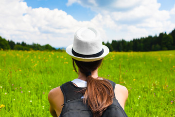 Young woman sitting relaxing in a green field setting.  People peace and relaxation in nature...
