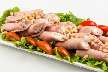 meat rolls with ham, cheese and greens, on white background