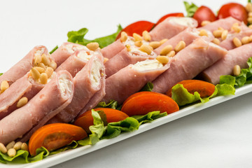meat rolls with ham, cheese and greens, on white background