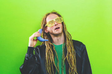 Funky fashion man with dreadlocks and painted quirky bananas