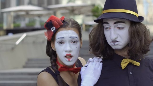 Young girl mime scared and turn away from camera holding hands by male shoulder
