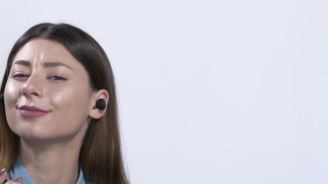 Ragazza con auricolari ascolta la musica e parla al telefono