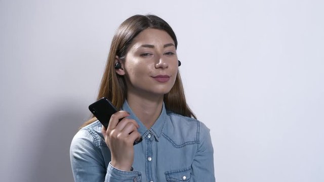 Ragazza con auricolari ascolta la musica e parla al telefono