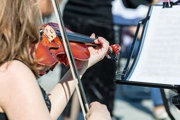 woman playing violin during classical music concert on the street